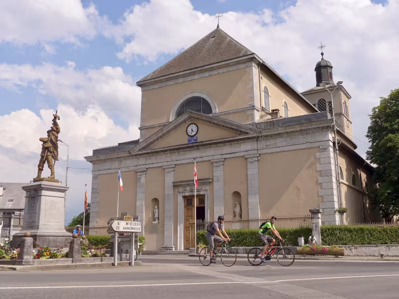 Ciclistas frente a la iglesia Saint-Jean-Baptiste de Taninges