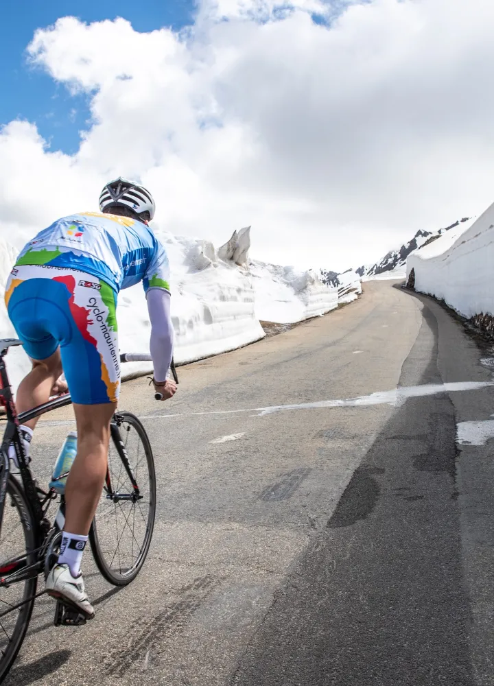 Ciclista en la nieve en la Route des Grandes Alpes