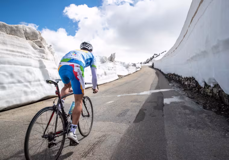 Ciclista en la nieve en la Route des Grandes Alpes