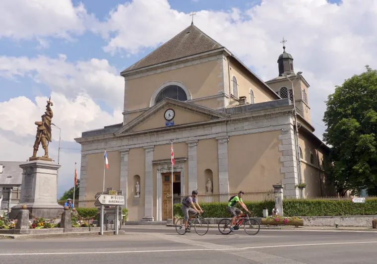 Ciclistas frente a la iglesia Saint-Jean-Baptiste de Taninges